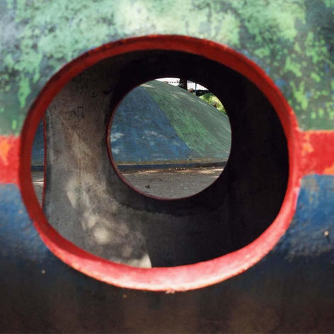 Abstract color photo showing a view through a colorful piece of playground equipment.