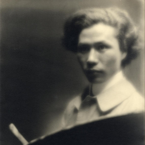 Soft focus warm toned black and white photo portrait of a young artist/painter of Asian descent.