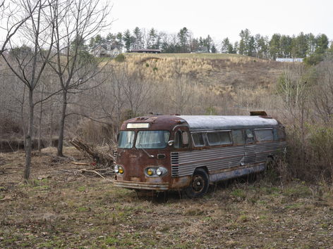 abandoned, rusted bus in landscape