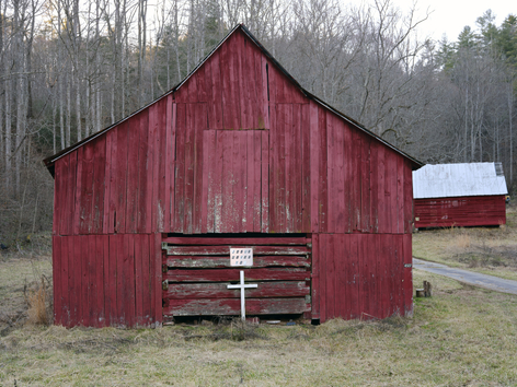 red barn with another red barn in the background
