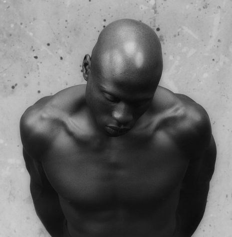 Black and white Mapplethorpe image of topless, bald black man