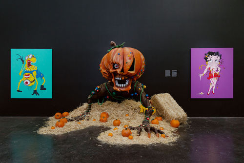 Alex Pardee's Giant Pumpkin installation with straw and pumpkins on floor