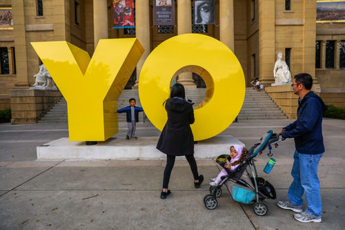 Gavin Gong, 4 (left) poses for a photo on Deborah Kass’ “Oy/Yo” sculpture outside the Cantor Arts Center in Palo Alto. Photo: Gabrielle Lurie, The Chronicle