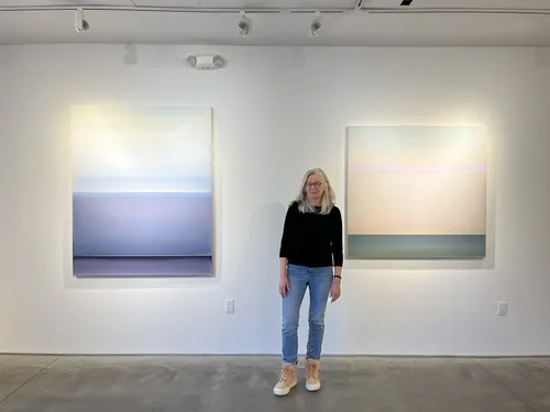 Susan English with two of her paintings.