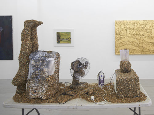 Laura Yuile​ Objects for the street​​ 2019​ Used and broken appliances (microwave, blender, iron, cctv camera, dehumidifier, child mannequin, fan), Grab adhesive, Pebbles,Table​ 175 x 180 x 75.5 cm​