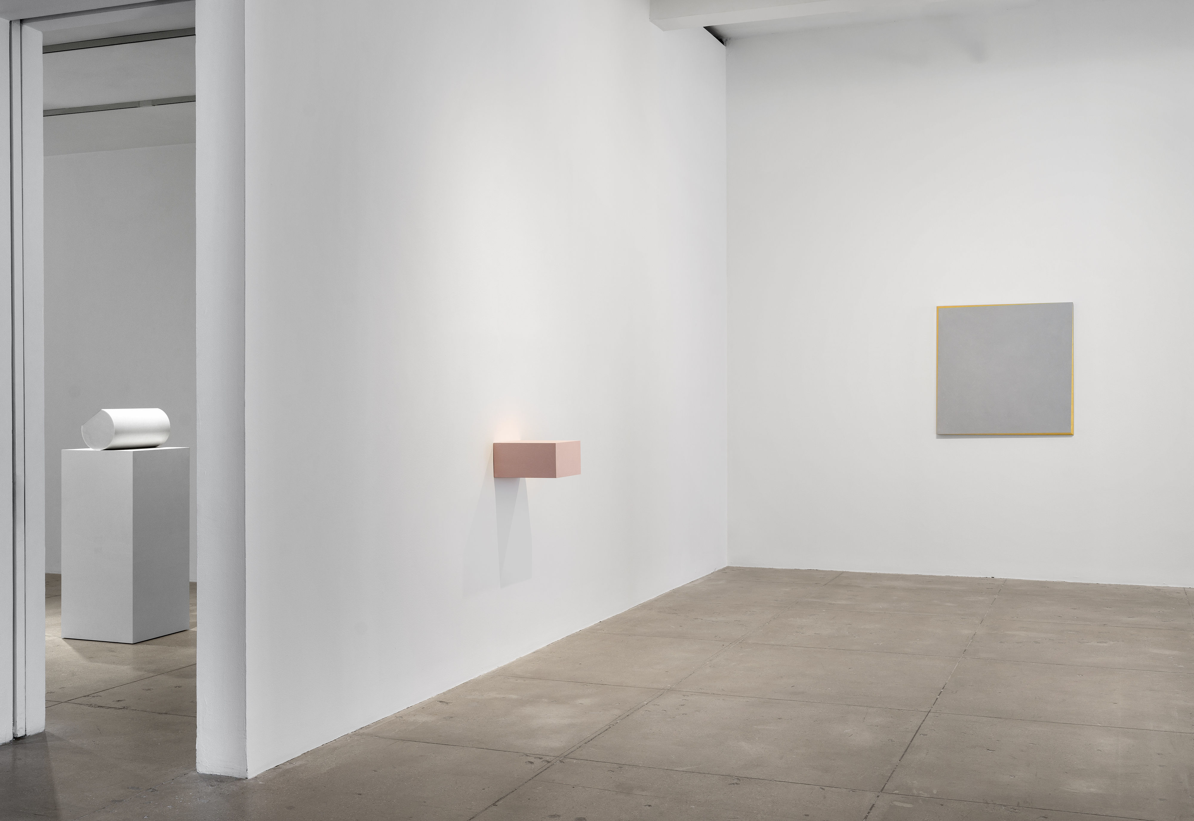 installation views of three works by Ettore Spalletti; one half-circle sculpture, one pink shelf-like sculpture and one light blue and gold painting with a three-sided bull frame.