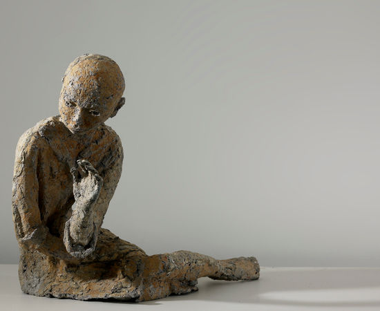 The front of a reclining woman who is made by paper mache. 