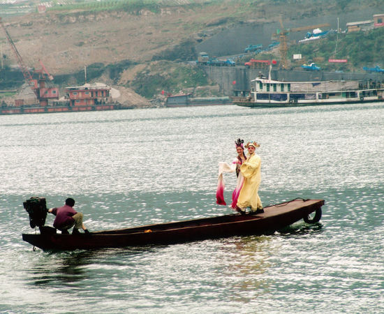 Two professional traditional (Chinese) opera actor and actress are on the little boat. 