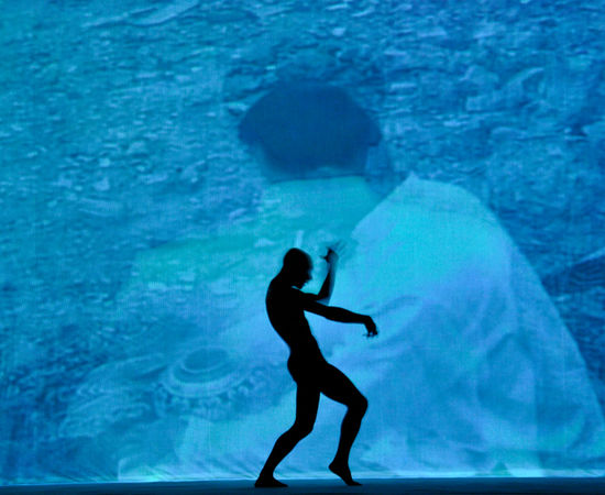 A male dancer is performing in front of Chen Qiulin's vedio work. 