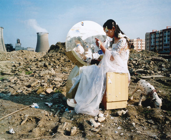 A fair maiden in white long skirt sits in front of a dressing table on the ruins
