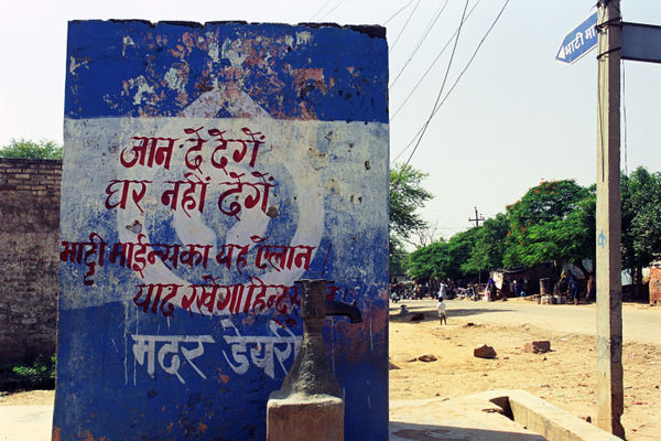 Ravi Agarwal Protest Slogan on Road Sign Bhatti Mines Village Delhi (Bhatti Mines Series), 2011 Archival Photographic Prints on Hannamule Rag White 310gsm Archival Paper 30.5 x 45.7 cm 12 x 18 in Edition of 5 plus 2 artist's proofs