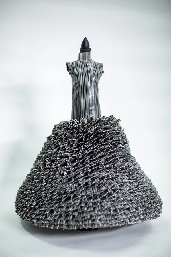 This garment is made entirely with the barcode from one of the official affidavit stamp paper. The stripes of barcode encode information such as ownership and identification. It is viewed as an ironic symbol, giving a nod to the disposable condition, emphasizing the need for individuality as well as the human body as commodity.