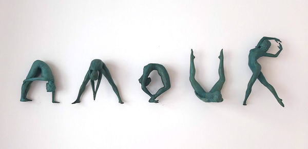 Sculpture de lettre « Love, amour », sculpture de jeune fille dansante de Marc de Corte, série « Words That Matter », sculpture contemporaine en bronze, sculpture figurative de femme, sculpture murale à la galerie Art Yi à Bruxelles.