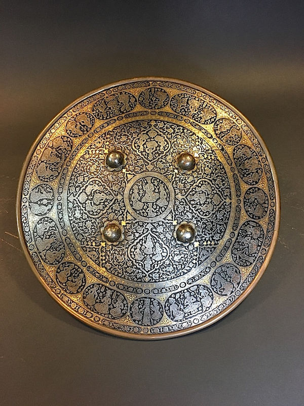 Steel round parade-shield richly engraved with figural scenes and decorated by four bosses