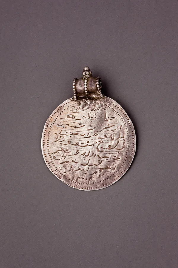 Silver circular talisman with Islamic inscription