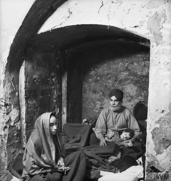 Bill Brandt, A Sikh Family sheltering in an alcove where coffins once stood, 1940