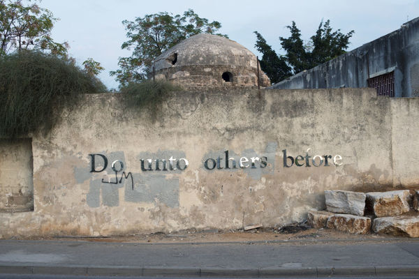 Shimon Attie, DO UNTO OTHERS BEFORE, Laser cut mirrored letters, Ruins of former Mosque attacked and damaged by rioting Israelis during second Palestinian Intifada, Tel Aviv, 2014