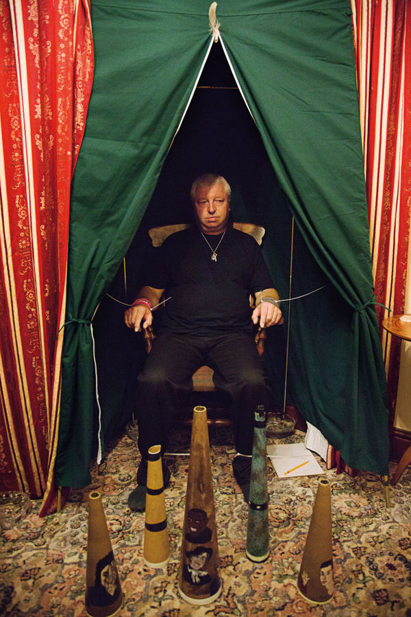 Shannon Taggart, Medium Chris Howarth in his medium’s cabinet, before a séance begins in his living room, UK, 2013