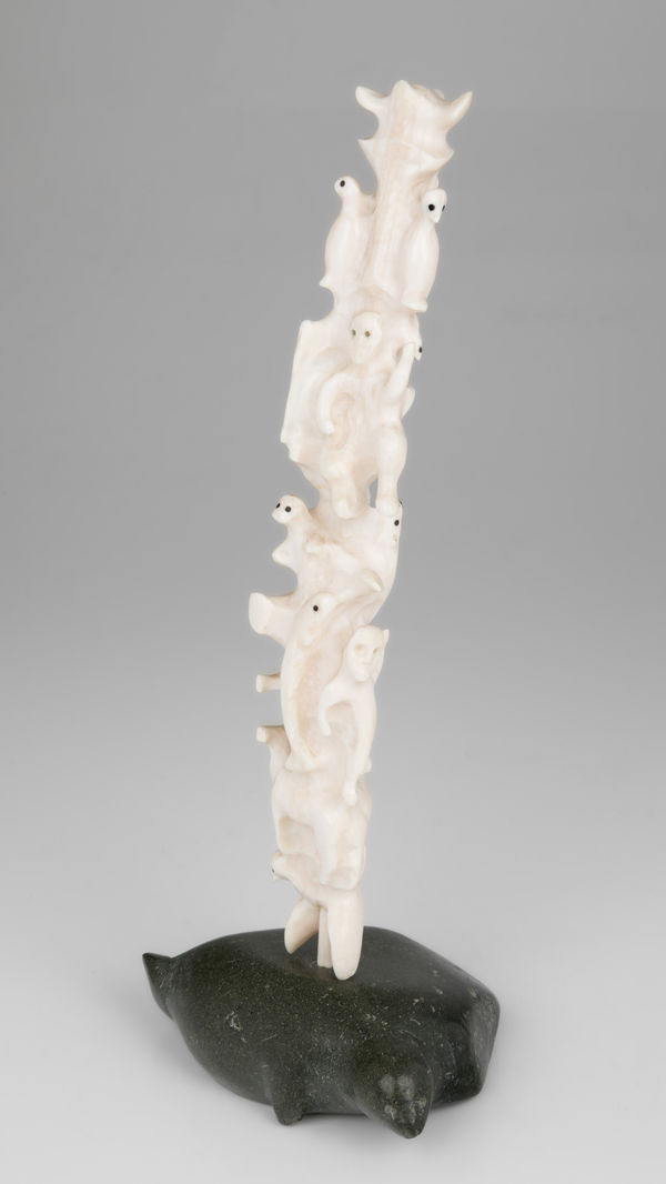 Lot 16 BERNADETTE IVALOOARJUK SAUMIK (1938-) RANKIN INLET (KANGIQLINIQ) Totemic Composition with Inuit and Owls on Seal Base, 1977 ivory, stone, and black inlay, 11.25 x 4.75 x 3.5 in (28.6 x 12.1 x 8.9 cm) ESTIMATE: $400 — $600 PRICE REALIZED: $244.00