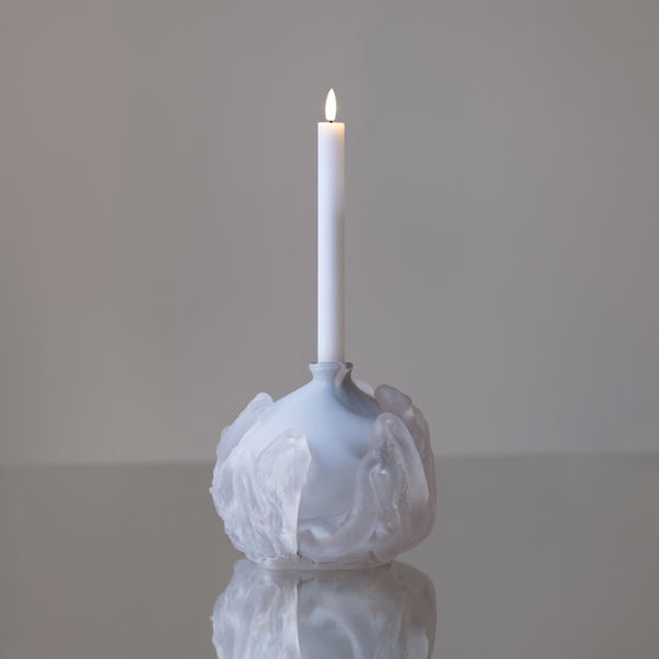 rund, vit, ljushållare i glas med ett levande ljus i