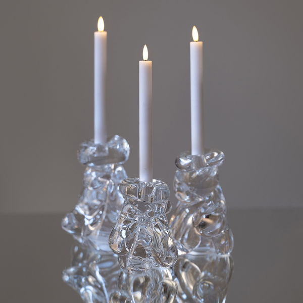 ljusstake i rinnande glas med ett ljus i