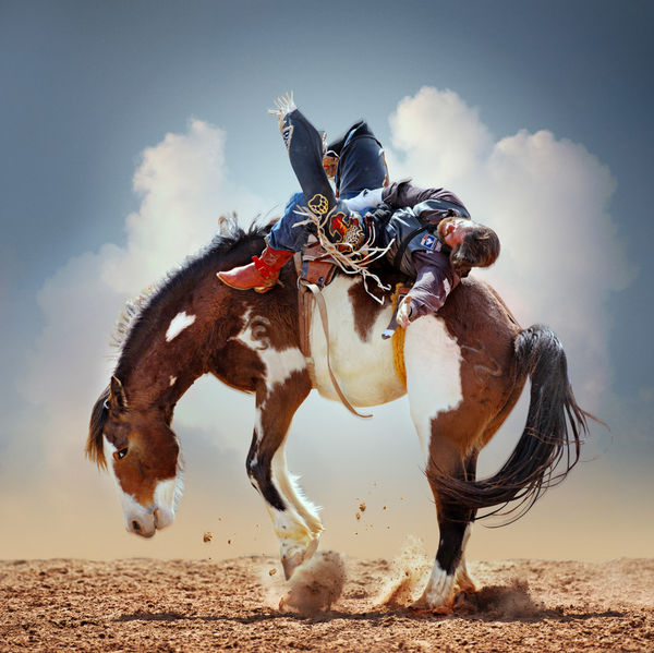 man neing bucked off a horse, caught in slow motion