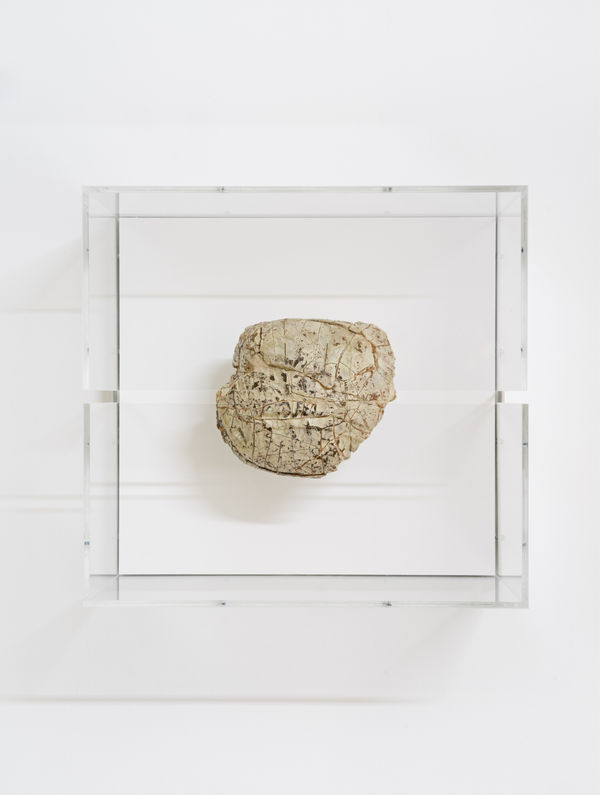 A mixed media piece in a glass case.