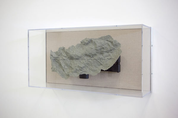 A rock framed in glass case.