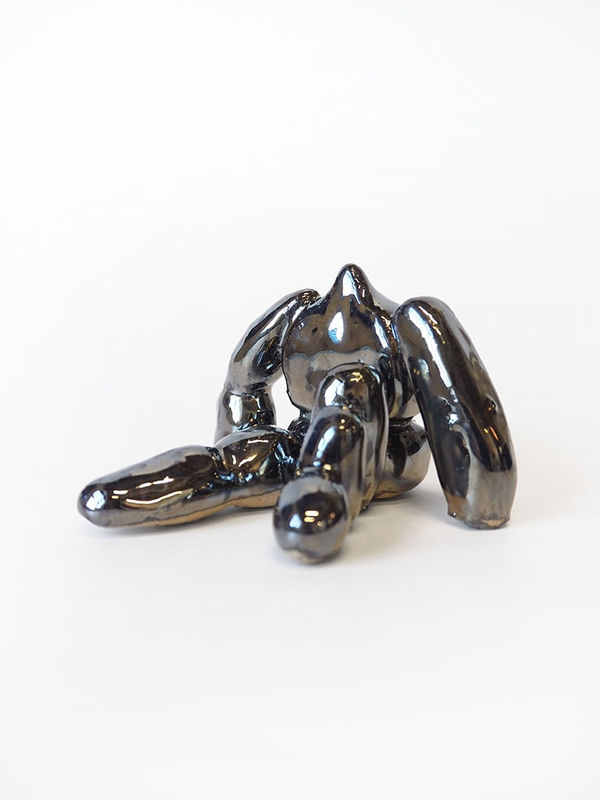 ceramic piece by Jocelyn Tsaih of a silver figure sitting