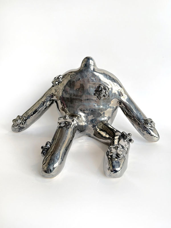 silver ceramic work with Jocelyn Tsaih of a body sitting with flowers on it