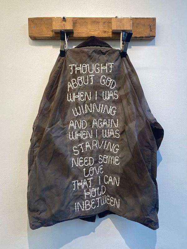 Henry Harper embroidered jacket hanging on wooden wall hook