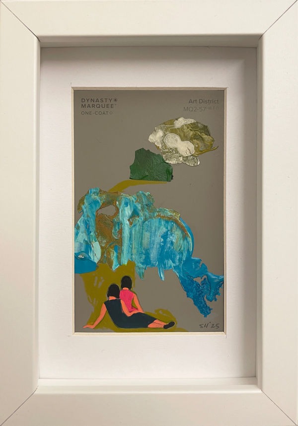 Painting on a gray paint chip of two woman sitting on green grass facing away in white frame