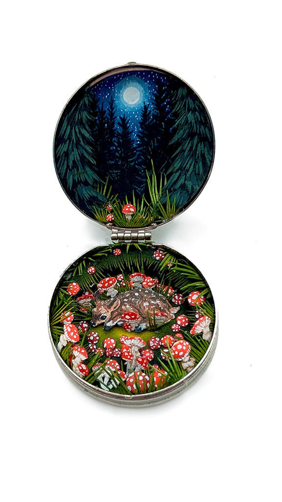 hand-cut watercolor collage in antique cosmetic compact by Shannon Taylor with forest night scape and baby deer surrounded by red mushrooms