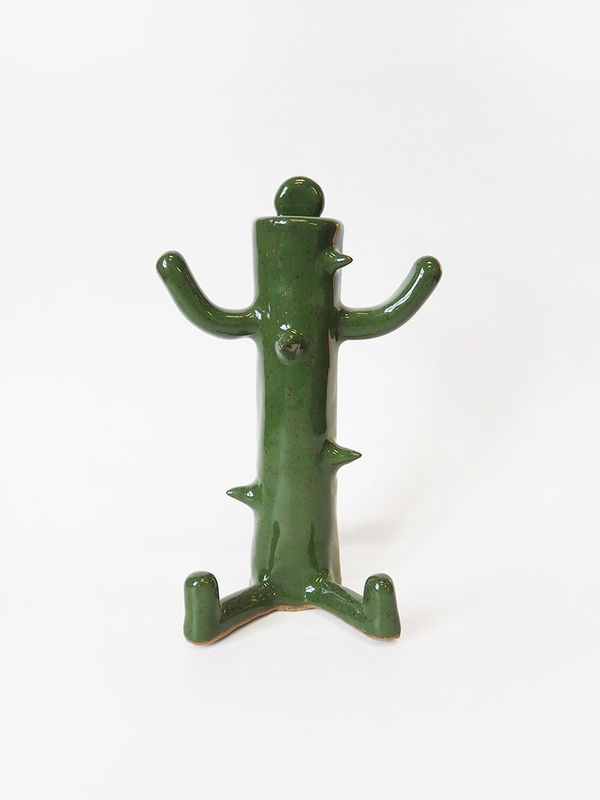 ceramic piece by Jocelyn Tsaih of tsall green figure sitting with cactus like thorns coming out of it