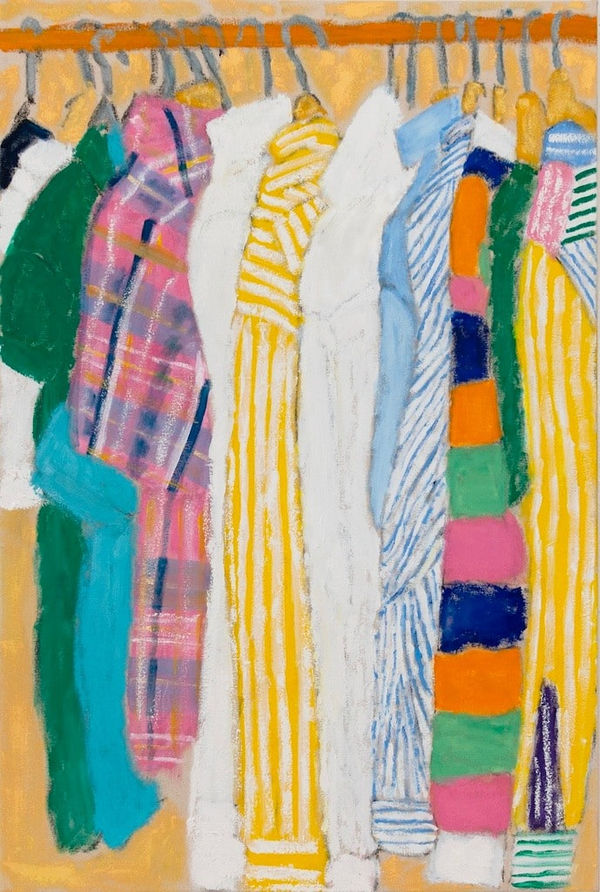 line of different shirts hung on hangers in a closet