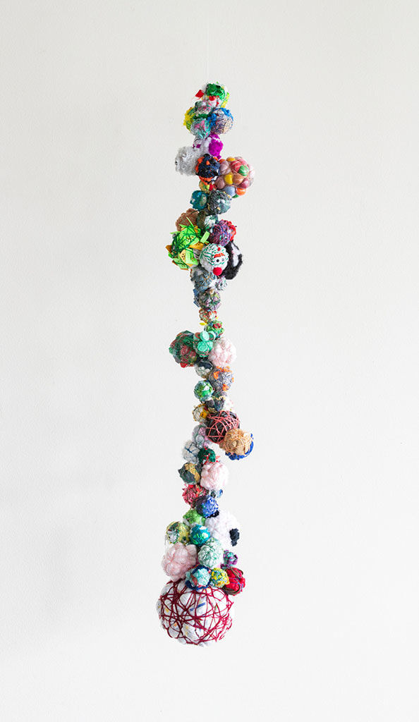 Hanging sculpture of miscellaneous items bound by a string
