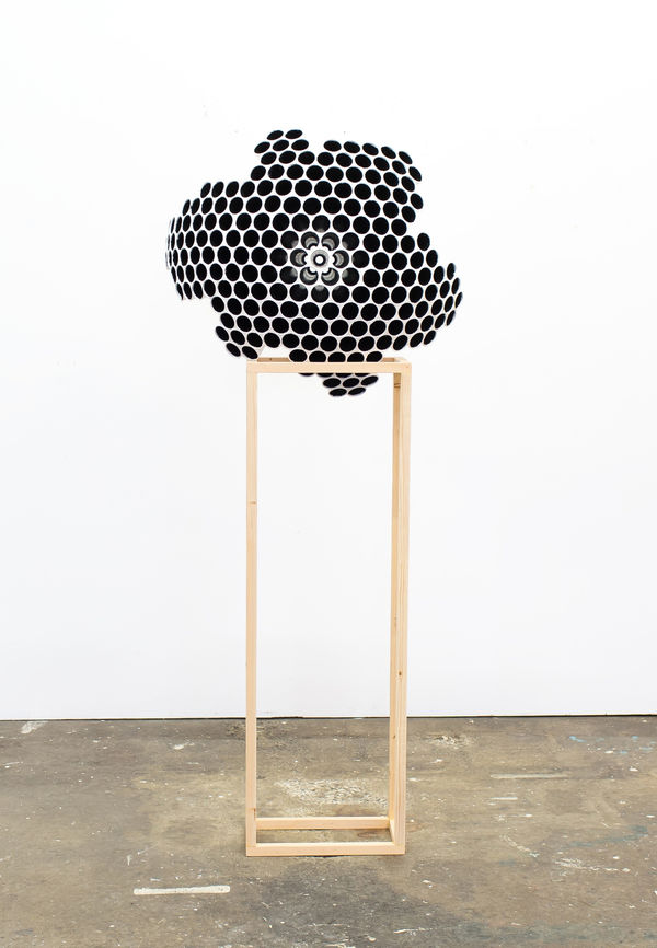 Mixed media sculpture with circular black pattern curved to form an incomplete globe The sculpture rests on a wooden rectangular frame