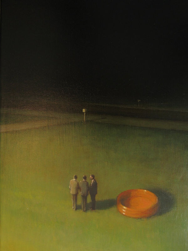 Three men stand huddled to the left of round orange inflatable pool in the middle of grass field with dimly lit background.