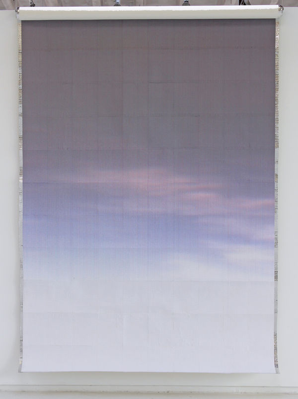 Printed paper of a purple and blue sunrise with faint thin clouds against aluminum foil