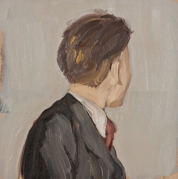 Man in suit with red tie gazes away from the viewer in front of a gray background. His body below the shoulders is cropped out of the composition.