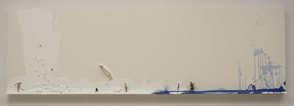 Long rectangular white canvas with white and blue splashes of paint on its surface. Amongst the paint multiple tiny figurines and found objects are scattered about