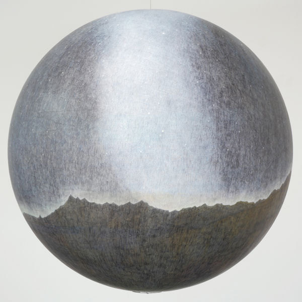 A hanging sphere shows a starry sky over a mountain range with a milky-white band vertically in the center