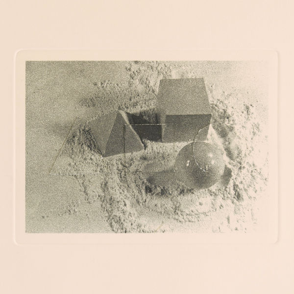 Print with white border of sand with cube, sphere, and pyramid. There is cut out of triangle, square, and circle matching print on top.