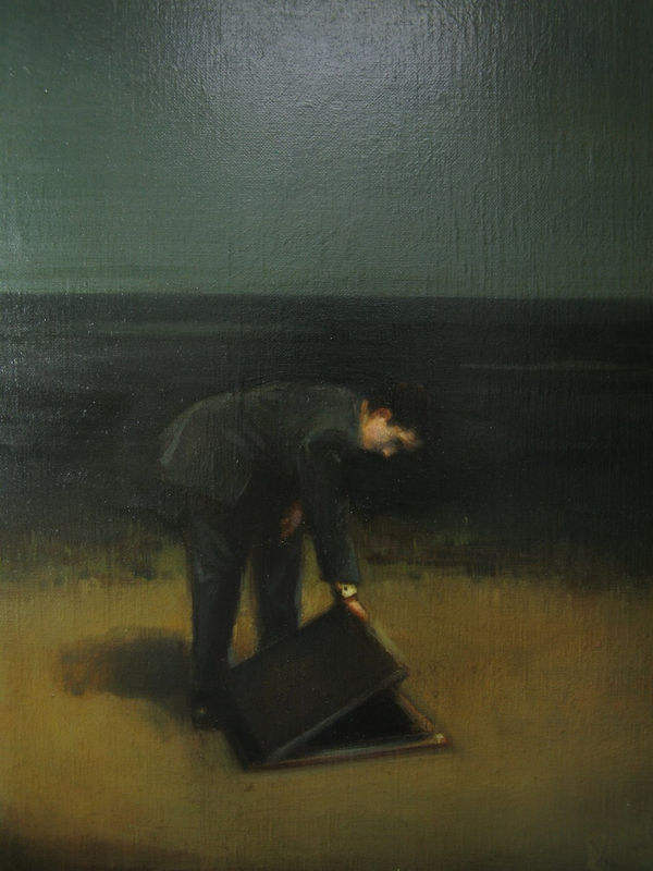 Man dressed in suit standing on yellow grass opens a trap door into the ground. Background is sea with bridge and sky separated by strong horizon line.