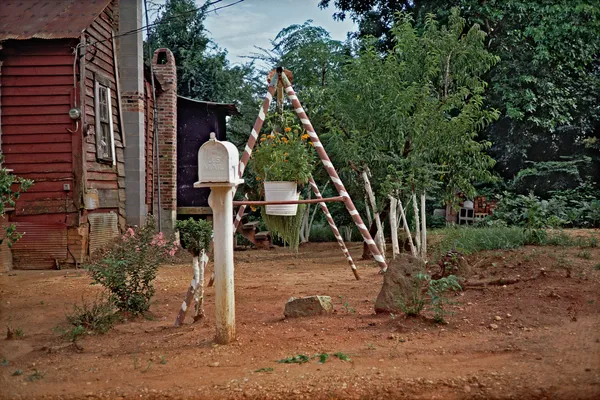 William Christenberry, Mailbox and Swing of House with Flowers, near Morgan Springs, Alabama, 1984