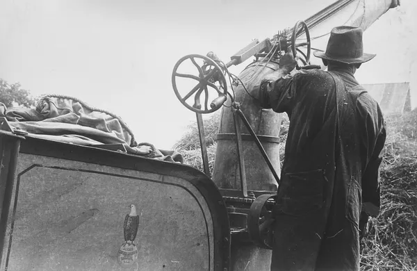 Ben Shahn, Adjusting straw stocker on grain separator, central Ohio, 1938