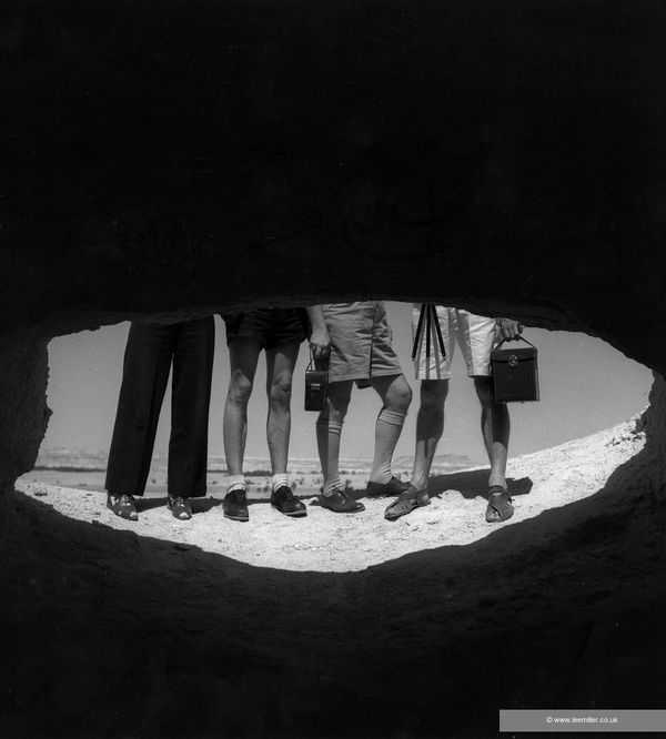 Lee Miller Untitled [Legs, Mafy Miller, thought to be Dimitri Papadimos, George Hoyningen-Heuné and Roland Penrose], Gebel Mawta, Siwa, Egypt, 1939 Fine Archival Gelatin Silver print. Non-Editioned. Image size: 25.3 x 25.3 cm (10 x 10 in) Paper size: 39.1 x 29.6 cm (15 3/8 x 11 5/8 in)