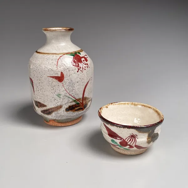 Stoneware tokkuri (sake flask) and guinomi (sake cup) with red and green floral patterning