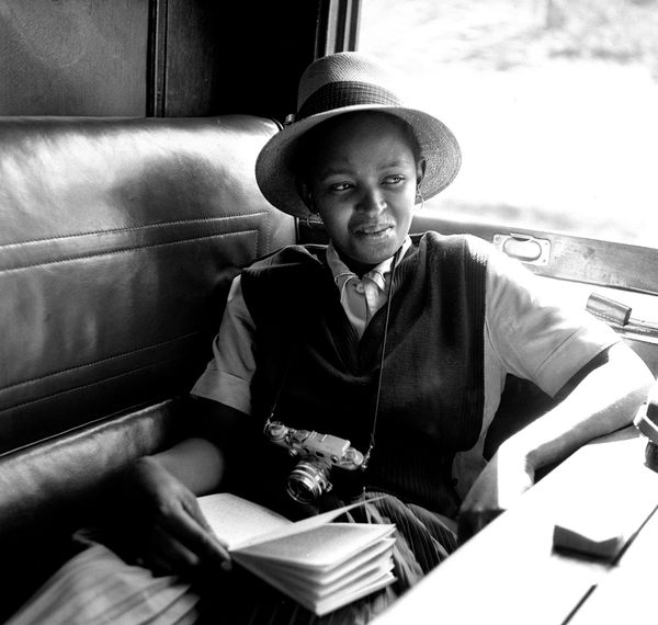Bob Gosani, Dolly Rathebe reading on train to Durban, c.1955