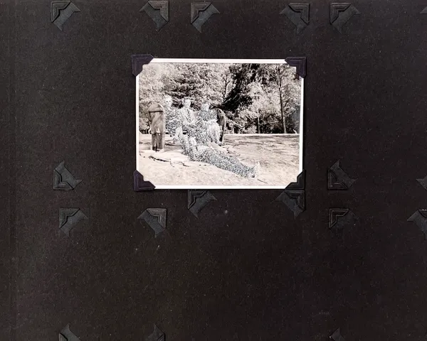 John Latour, Two women with crossed legs sit on either side of a man on a bench. A second man stretches out on the lawn, at their feet. Everyone is smiling, 2020